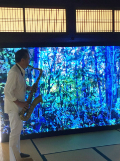 絵画と映像による桃与さんのアート作品を前にコラボ演奏する松本さん