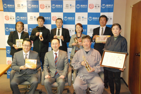 表彰式で受賞作を手に、皆川市長（前列中央）と記念撮影した受賞者たち