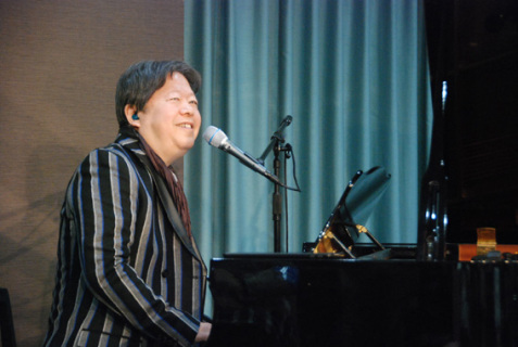 就任式後、ピアノ弾き語りを披露するタケカワさん