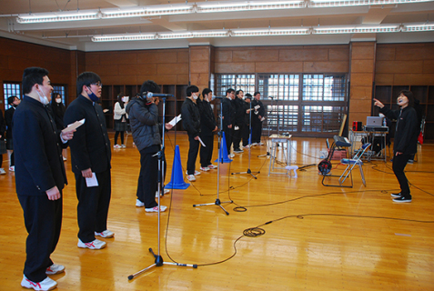 工藤さん（右）の指示でコーラスを録音する山添校の生徒たち