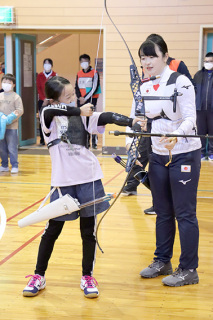 「おもーい」。中村選手（右）の弓を引く小学生