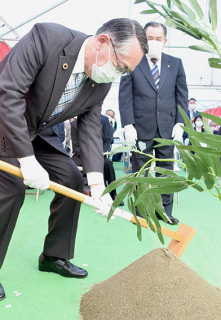 丸山市長（左）、西村社長がくわ入れし、工事期間中の無事故を祈念