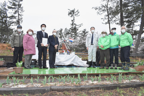 開園3年目を記念して造られた「オランダ友好花壇広場」で記念撮影する関係者