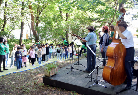 日和山楽団メンバーの演奏で合唱を披露する園児たち