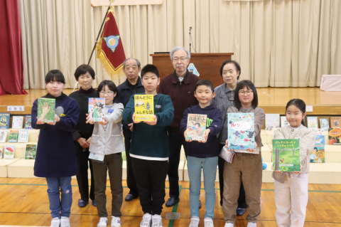 羽黒小の子どもたちに本をプレゼントした4人。後列左から齋藤さん、佐藤さん、生田さん、小関さん