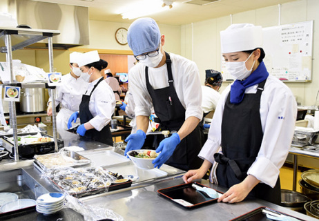 人気で注文が殺到し、大忙しでラーメン作りに取り組む生徒たち＝27日午前