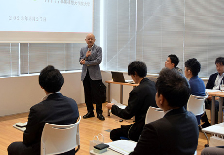 河村教授（中央）の話に聴き入る研究員たち。プロジェクト研究を通し新事業・サービスの開発に取り組む