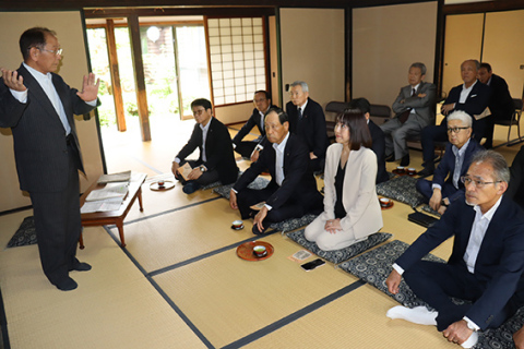 菅さん（左）から「南洲翁遺訓」の編さんや南洲翁と臥牛翁の徳の交わりについて説明を受ける鹿児島商議所の一行＝1日、鶴岡市・菅家