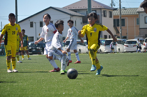 真夏の暑さにも負けず、小学生たちが緑の芝の上を駆け回った＝11日