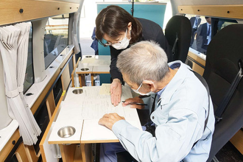 車内で手続きを行う申請者