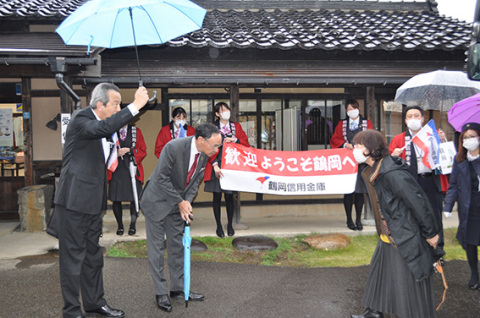 鶴岡信金の佐藤理事長（左から2人目）や若手職員がツアー客を出迎えた