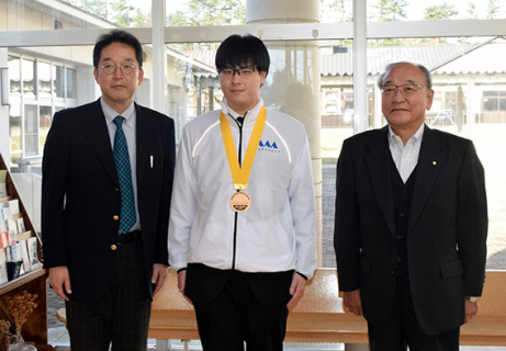 全国銅賞を受けた土門さん（中央）を囲む五十嵐校長（左）と上林会長