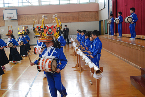 低学年は竹竿をばちでたたき、中学年は太鼓、高学年は太鼓と踊りを披露した