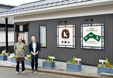 店舗前で記念写真に応じる井山さん（左）と小松さん