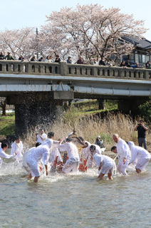 白装束姿の男衆が威勢よく水を掛けた伝統の「神輿流し」