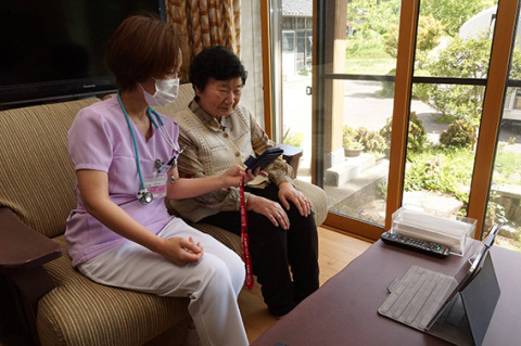 自宅で看護師とオンライン診療を受ける女性患者