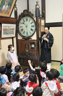 渡邊副住職から塔時計の歴史を聞く常念寺保育園の園児たち