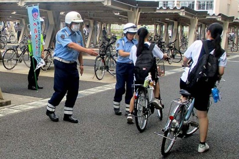 登校する生徒たちに自転車ヘルメット着用を呼び掛けた＝酒田警察署提供