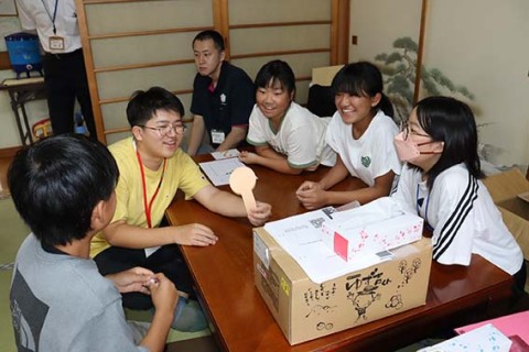 「〇×クイズ」で交流を深める曽於市と鼠ケ関小の子どもたち＝30日、越沢地区「まやのやかた」