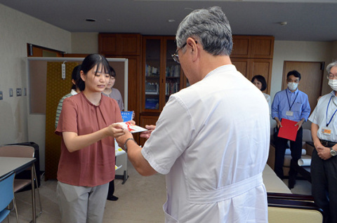 島貫理事長に寄付金を手渡す伊藤さん（左）