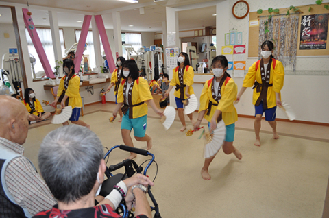 福祉施設を利用するお年寄りたちの前で、子どもたちが伝統の「みかぐら」を披露した＝福祉のひろばいなおい