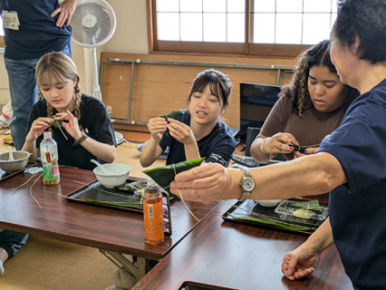 伊藤さんの指導（右）で女子大生らが笹巻作りに挑戦した