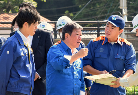 酒田市大沢地区で被災状況の説明を受ける茂木幹事長（中央）