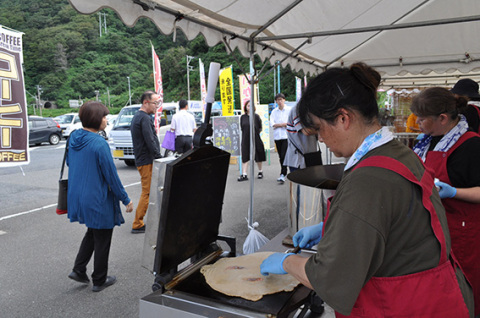 プレス機で紅エビせんべいが焼き上がると、香ばしい匂いが漂い観光客が足を止めた＝14日