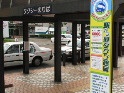 「駅から観タクン鶴岡」の運行開始を告げる看板＝ＪＲ鶴岡駅のタクシー乗り場