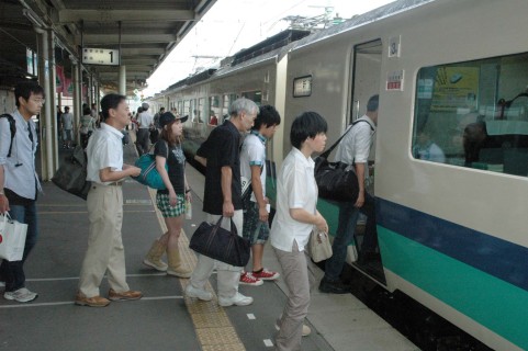 大きな荷物を抱えながら特急列車に乗り込むＵターン客＝15日午前、ＪＲ鶴岡駅