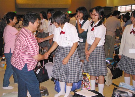 開校式で田園調布学園の生徒たちと受け入れ家族が笑顔で握手を交わした