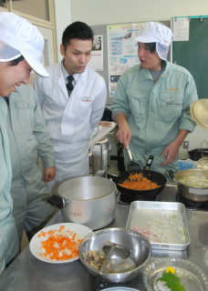 庄内浜文化伝道師の須田さん（右から2人目）から料理のコツを教わる生徒たち