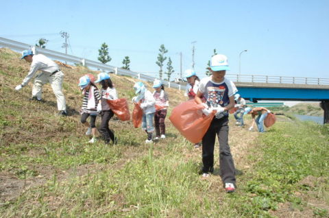 大山川河川敷の清掃活動に取り組む大山小児童たちと青年部のメンバー