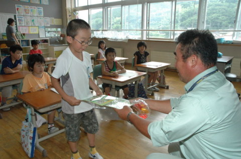 児童たちに交通安全と防犯に関するグッズを贈った＝三瀬小