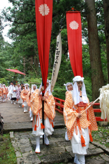 神子修行が始まり、そろいの装束で羽黒山頂に向かう参加者たち＝6日午前11時40分ごろ