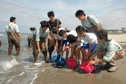 水高生とともにヒラメの幼魚を放流する湯野浜小の児童