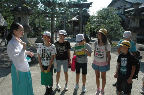 鶴岡市内を巡る「城下町探検」に取り組む朝三小と鹿本小の児童たち＝15日、荘内神社