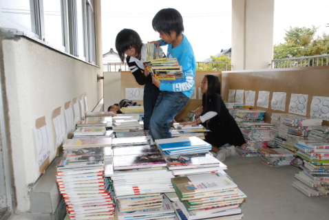 富士見小の 5 年生が図書館の書架から取り出した本をベランダに並べた