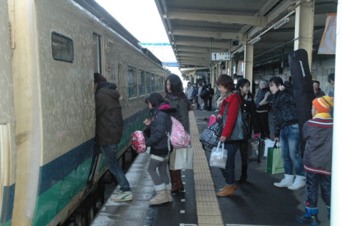 ＪＲ鶴岡駅では大きな荷物を抱えて上り列車に乗り込む帰省客の姿が見られた＝3日午前