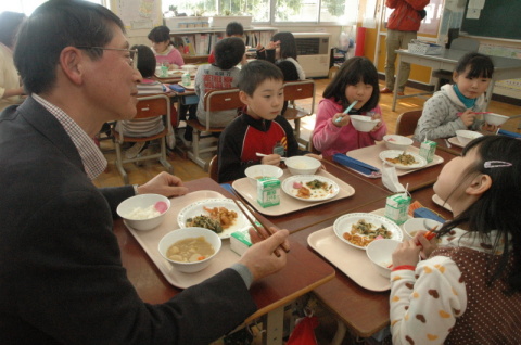 生産者と一緒に有機米の給食を食べて交流する児童たち＝鶴岡市の東栄小