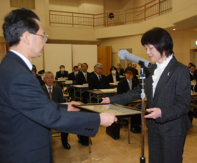 栗田教諭（右）が中目教育委員長から表彰状を受け取った