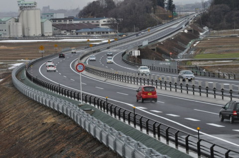 開通後初の日曜日となった25日、開通区間の上下線とも走行車両が続いた＝鶴岡市大広付近