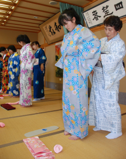 華やかな浴衣に身を包み、帯の締め方などについて学ぶ立川中の生徒たち