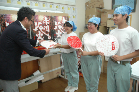 赤川花火大会の公式大会グッズのうちわを納品する鶴高養の生徒たち