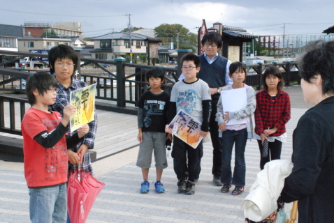 浜田小の4年生が光丘の生涯を描いた紙芝居を口演する「子ども紙芝居ガイド」を務めた＝山居橋