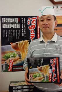 お土産用「酒田のラーメン」を手にする加賀屋組合長