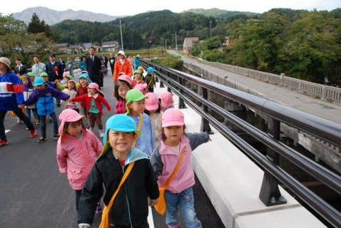 新設の「下本郷橋」を渡る地元保育園児たち。右手奥に見えるのが旧本郷橋