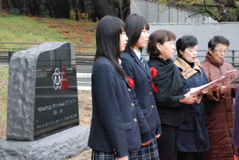 除幕された記念碑の前で3月まで酒田中央高生だった2人と同校卒業生が校歌を斉唱した