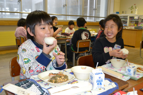 塩味のおにぎりにかぶりつく児童＝7日、朝暘三小