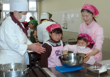 協力してケーキ作りを体験する親子連れ